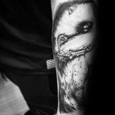 black and white tattoo of an eagle with big eyes on his arm, done by the artist