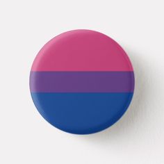 a pink and blue button on a white wall