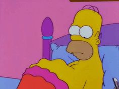 the simpsons is laying in bed with an unmade pillow on his stomach and holding a pen