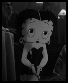 an animated image of a woman with big eyes sitting on a chair in front of a man