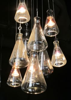 an assortment of glass hanging lights in a dark room