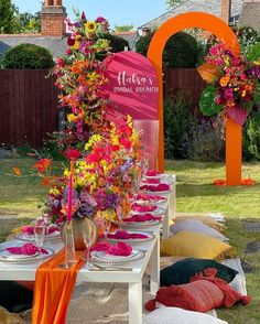 a table set up with flowers and candles for an outdoor wedding reception in the backyard