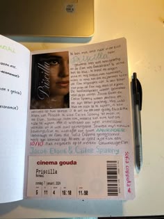 an open book on a table with a pen and laptop in the background, next to it