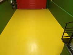an empty yellow floor in a green and red room with stairs leading up to the door