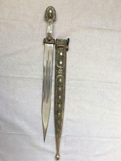 an old knife is laying on a white sheet