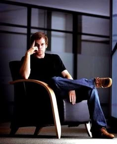 a man sitting in a chair talking on a cell phone