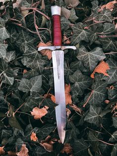a knife that is laying on some leaves
