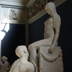 there is a white statue in the middle of a room with other statues around it