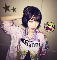 a girl with black hair and glasses is holding her head in front of the camera