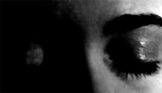 a close up view of an eye with the iris partially open and visible, in black and white
