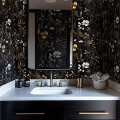 a bathroom sink sitting under a mirror next to a wall mounted faucet with flowers on it