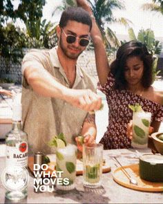 a man and woman sitting at a table with drinks