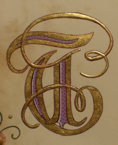 an ornate gold and purple monogrammed letter