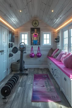 there is a gym room with pink and purple decorations on the walls, along with exercise equipment