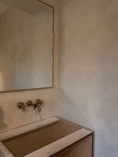 a bathroom sink under a large mirror in the middle of a room that is being remodeled