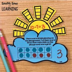 there are two pencils on the table next to a book with numbers and pictures