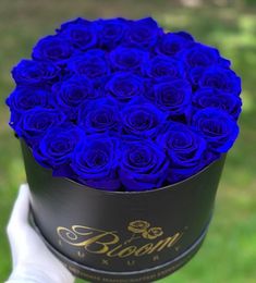 a black hat box filled with blue roses