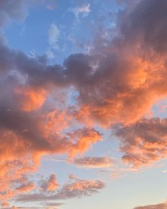 an airplane is flying in the sky with clouds above it at sunset or sunrise time