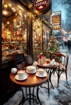 an outdoor cafe with christmas lights on the windows and decorated tables in front of it