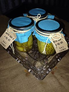 three jars filled with pickles sitting on top of a glass tray
