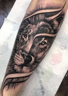 a black and white tattoo with a lion on it's arm, in the middle of