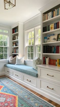 a room with many books on the shelves and a large rug in front of it