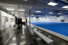 an empty room with blue carpet and white benches