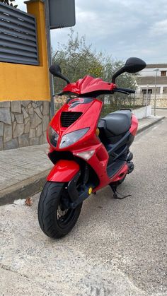 a red scooter is parked on the street