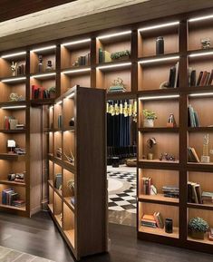 an open bookcase with many books on it in a room that is decorated with wooden shelves