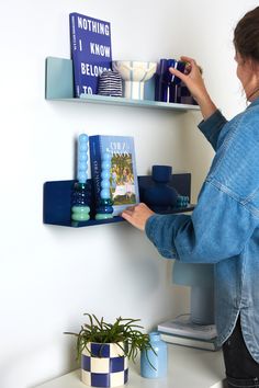 a woman is reading a book on the shelf