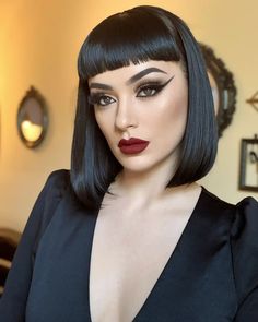 Let’s close with a look that’s pure drama. This architectural stacked bob haircut fall color combination is sleek, jet-black, and augmented with dramatic baby bangs that seem like a couture retro. The outlines are incisive, the aesthetic bold, and the fashion? Absolutely intentional. Bob And Bangs Hairstyles, Rockabilly Short Hair, Black Bob With Bangs, Goth Bob Haircut, Gothabilly Hair, Betty Bangs, Fall Color Combinations, Short Shaggy Bob, Short Bob Styles