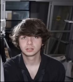 a young man sitting in front of a computer monitor