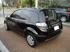 a small black car is parked on the street