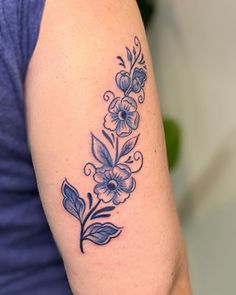 a woman's arm with a flower tattoo on the left side of her arm