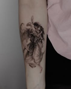 a woman's arm with an angel tattoo on the left side of her arm
