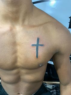 a man with a cross tattoo on his chest