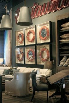 a living room filled with white furniture and lots of pictures on the wall above it