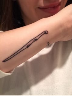 a woman's arm with a tattoo on it that has an arrow in the middle