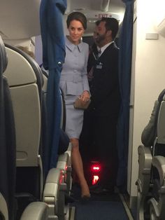 a man and woman standing on an airplane