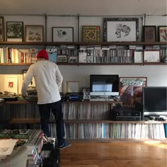 a man standing on top of a hard wood floor in front of a computer desk