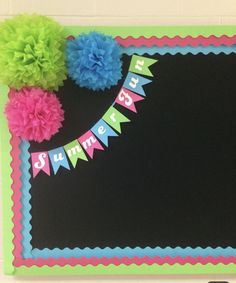 a happy birthday sign with pom poms on it