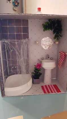 a dollhouse bathroom with a sink, toilet and bathtub is shown in the box