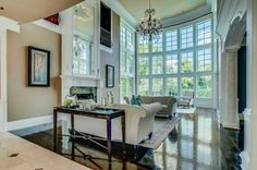 a living room filled with furniture and large windows