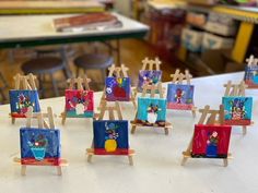 there are many small easels with paintings on them