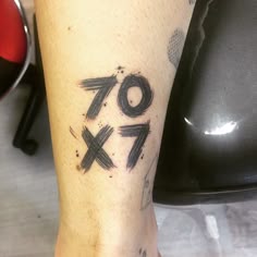 a close up of a person's foot with tattoos on it and the number seventy