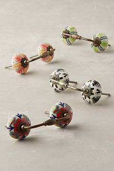 four pairs of colorful flowered earrings on top of a white surface with metal posts