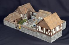 a model of a house on a black background with white trimmings and brown roof