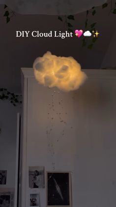 a white cloud is floating in the air above a room with pictures on the wall