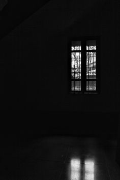 an empty room with two windows and no one is in the dark or on the ground