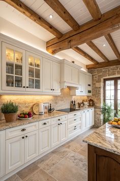 a large kitchen with white cabinets and marble counter tops, along with wooden beams in the ceiling